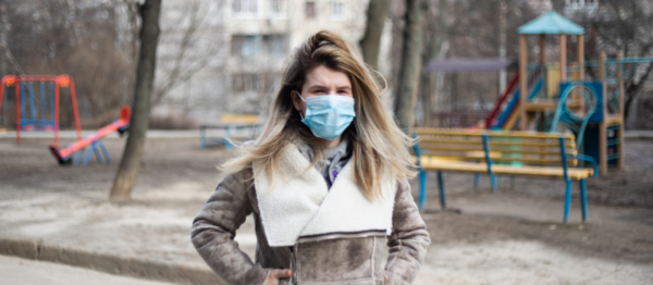 Woman with covid mask walking away from playground