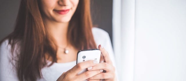 A young woman texting somebody on her phone