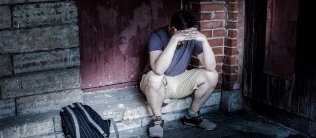 Man sitting on a stoop, locked out of the house and wondering to himself, “can my wife kick me out of the house?