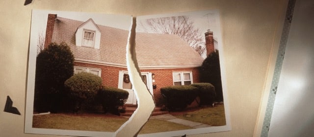 A ripped photo of a red brick house