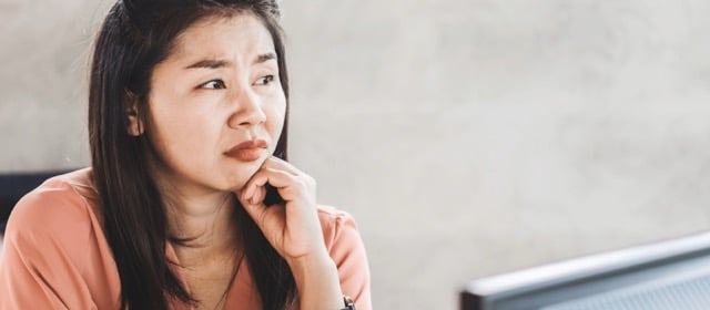 A concerned woman looking away and thinking whether she can sue her ex for emotional damage