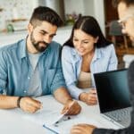 Real estate agent with couple closing a deal and signing a contract Couple reviewing a prenuptial agreement in Texas with an attorney